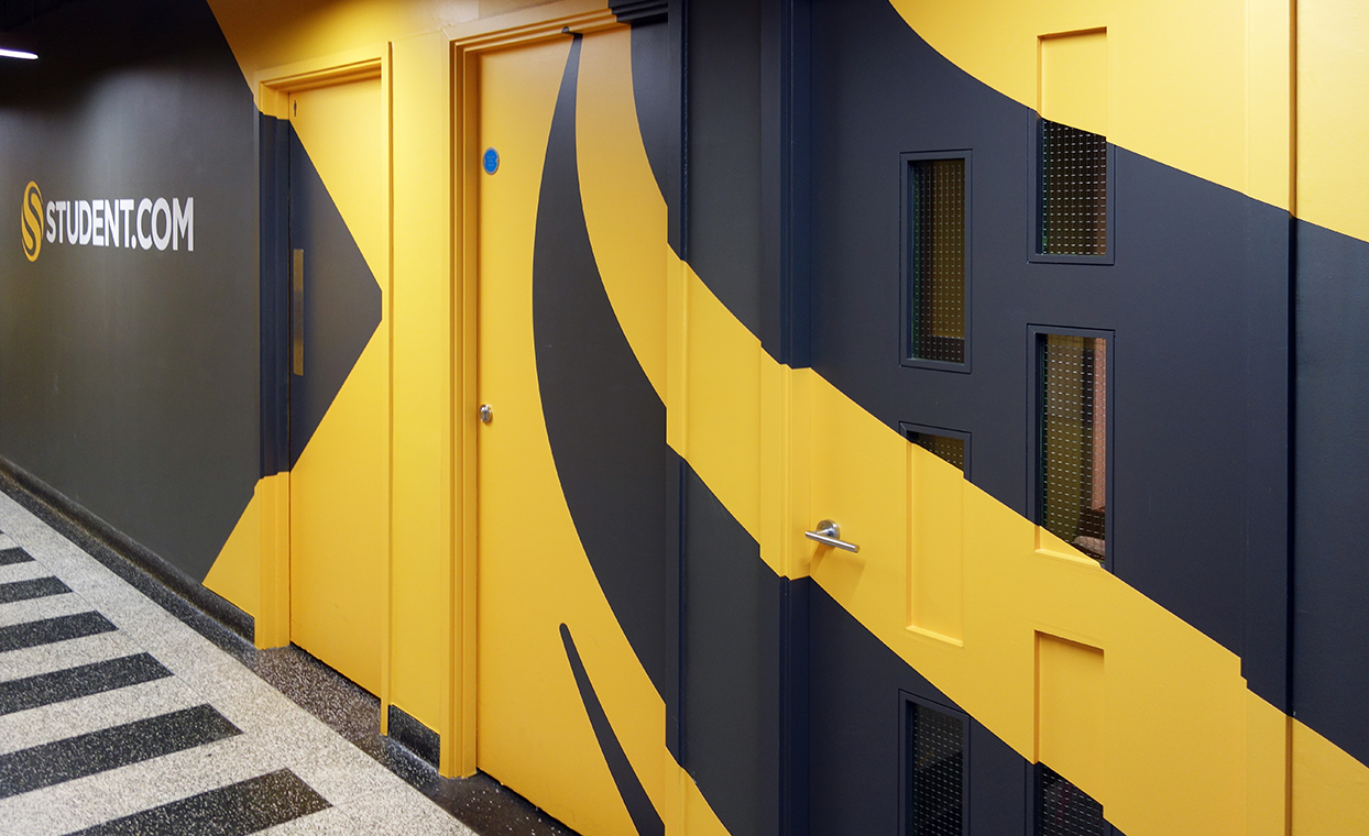 student.com name printed on vinyl for wall branding with matching striking yellow & black walls