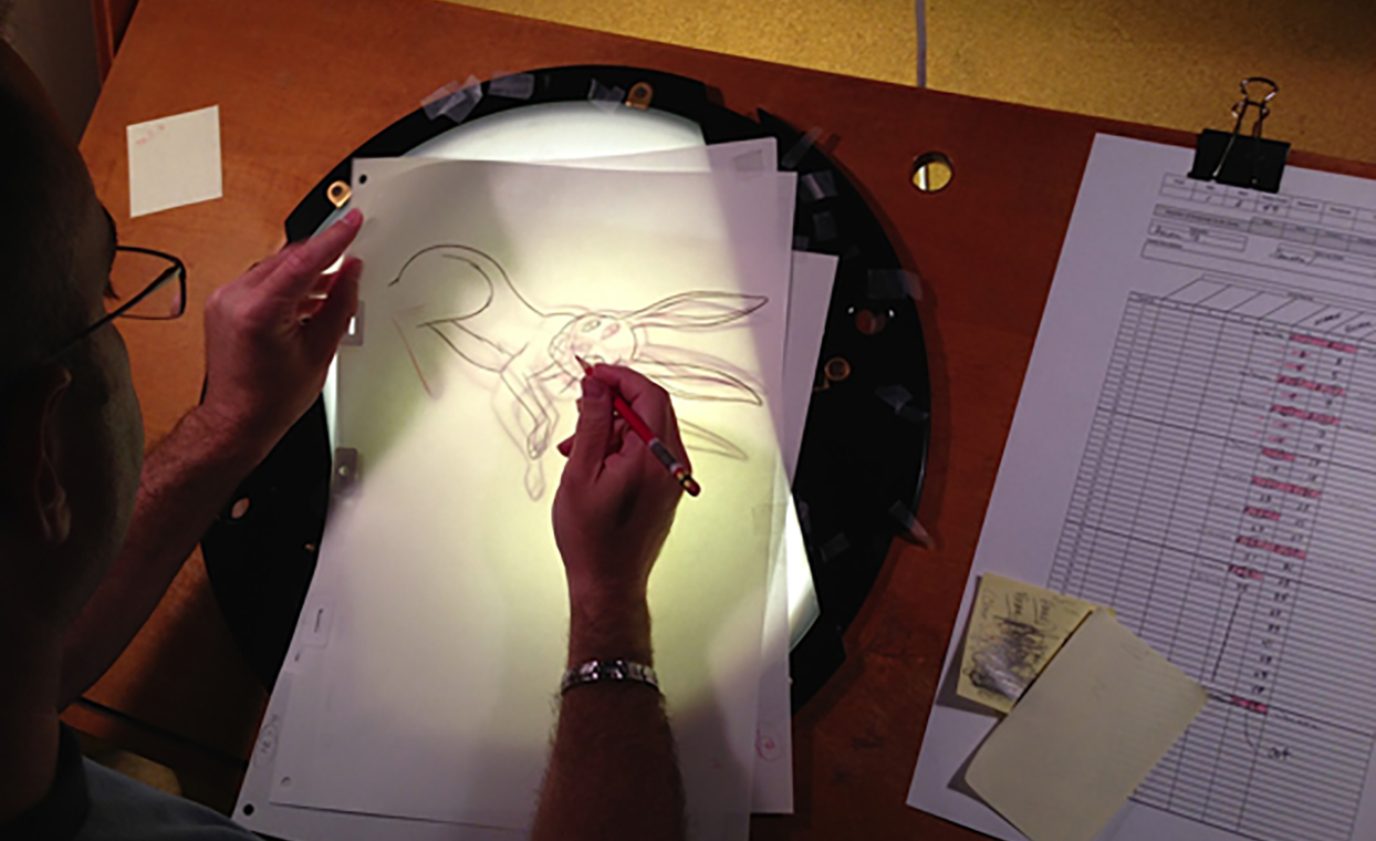 Disney artist Aaron Blaise hand drawing the Hare onto paper with light in background