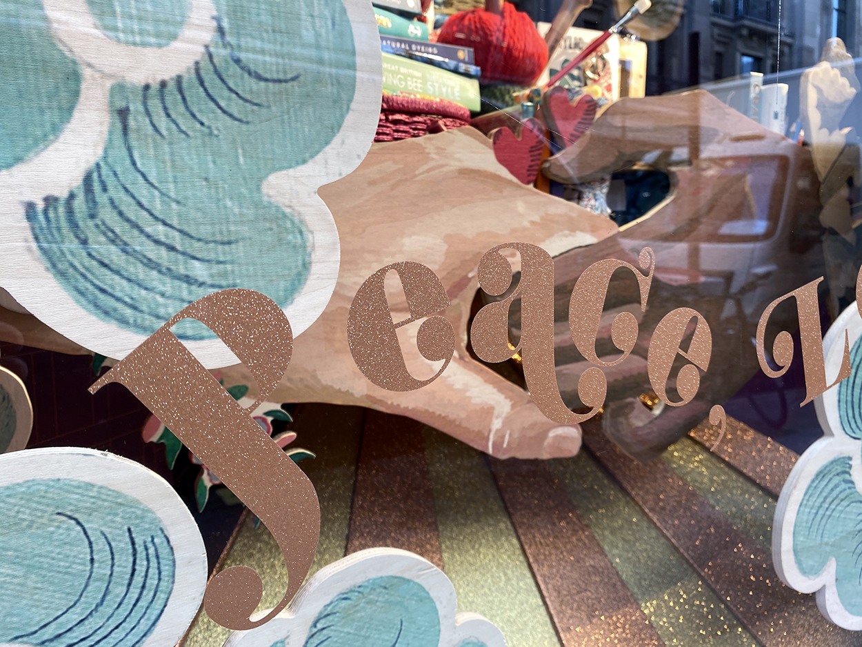 Gold glitter personalised decal writing on the retail windows for Christmas at Liberty in London