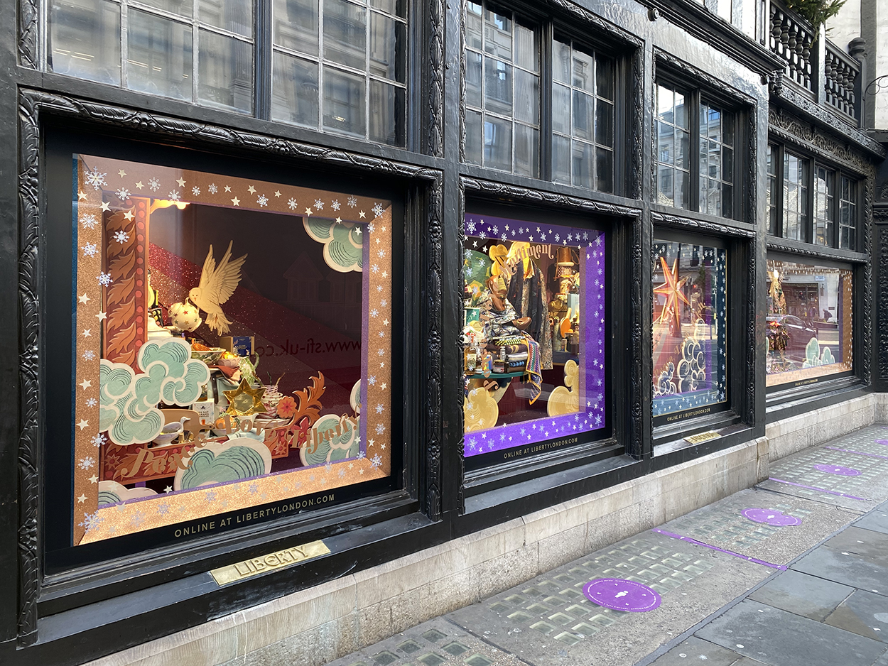 Four large full street view retail windows displayed with Christmas decoration at Liberty's