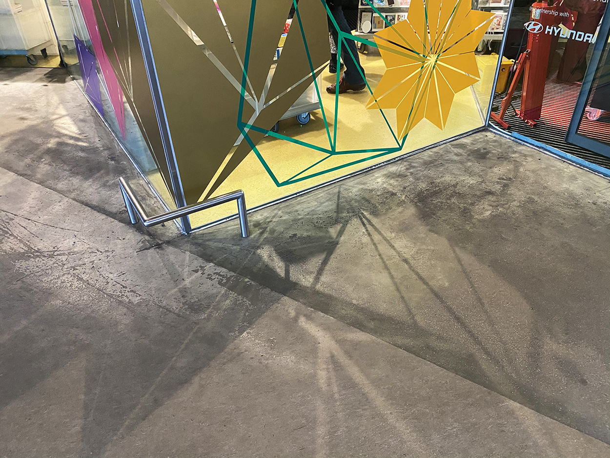 Large gold cut vinyl decal shapes displayed on window glass at the Tate Modern shop