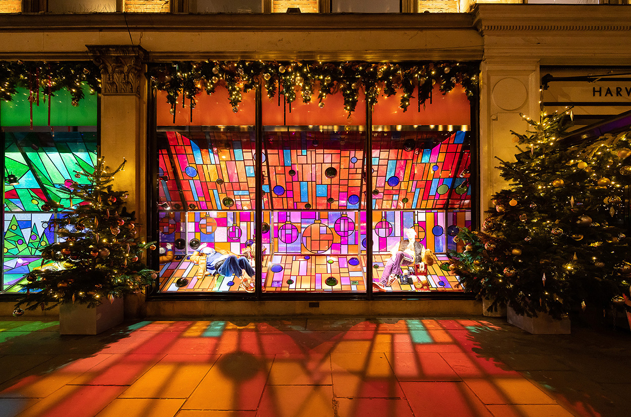 Brightly coloured stained glass themed Christmas Windows, reflecting light onto pavements