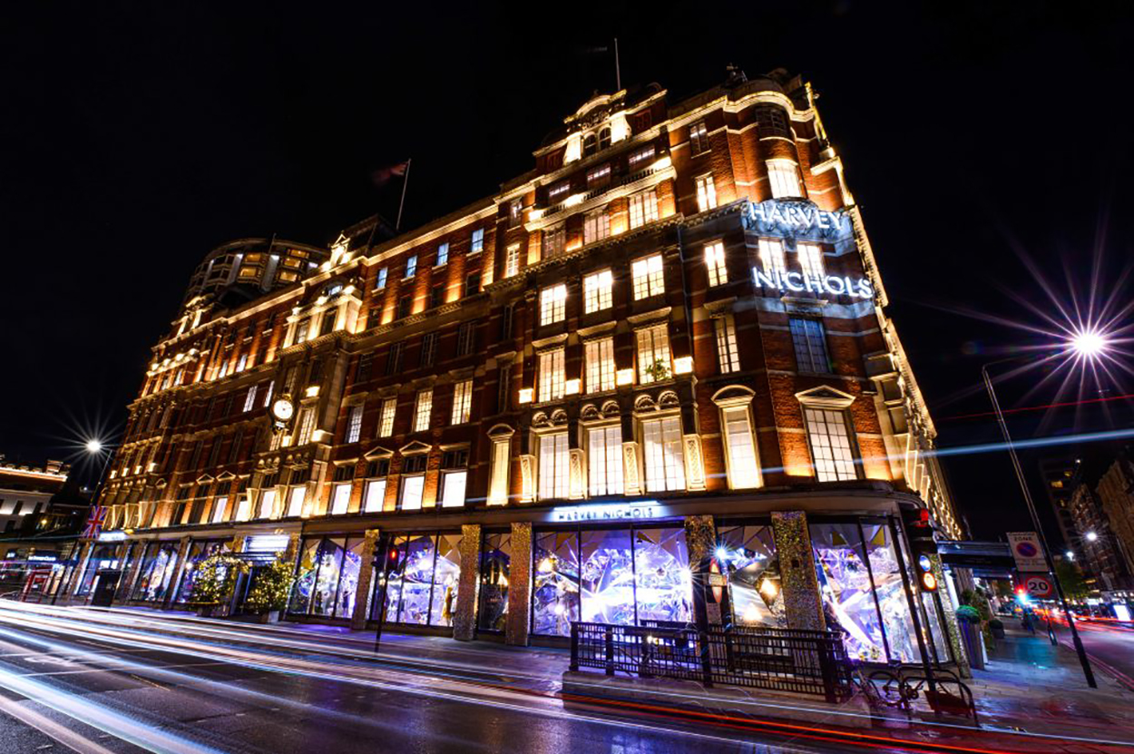 The iconic Harvey Nichols store in Knightsbridge London, with the Christmas windows lit up at night